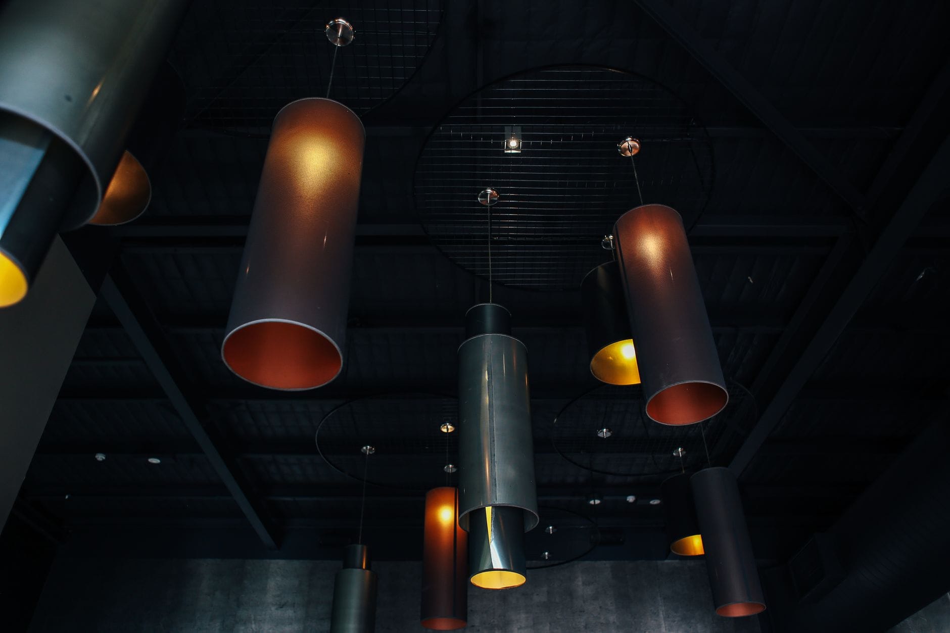Industrialne lampy wiszące na tle ciemnego sufitu Industrialne lampy wiszące na tle ciemnego sufitu