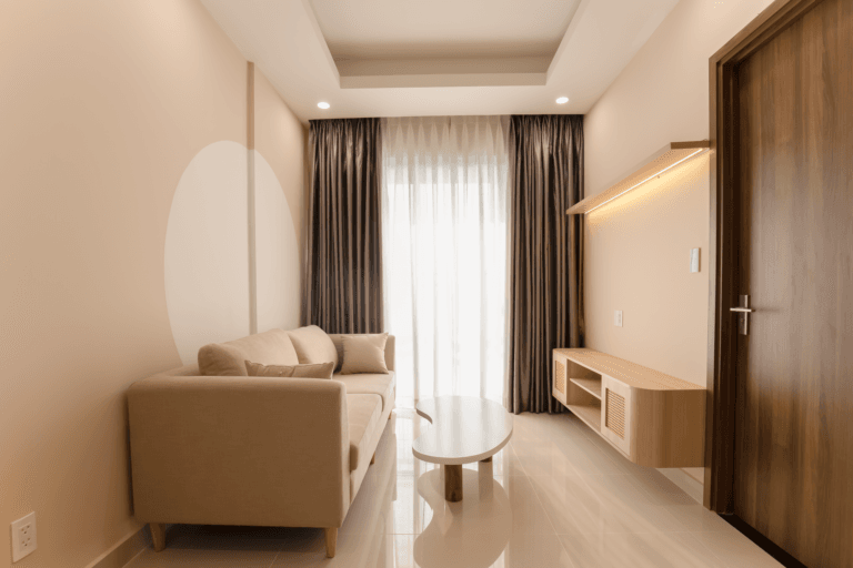Minimalistyczny salon z beżową sofą, stolikiem i miękkim oświetleniem