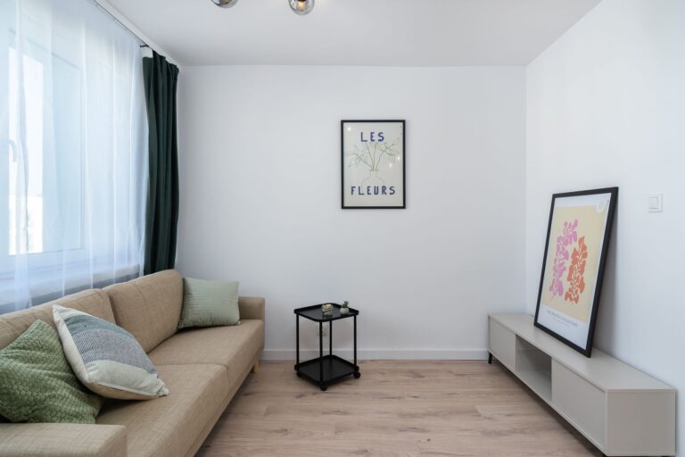 Minimalistyczny salon z przytulną sofą i obrazami na ścianie